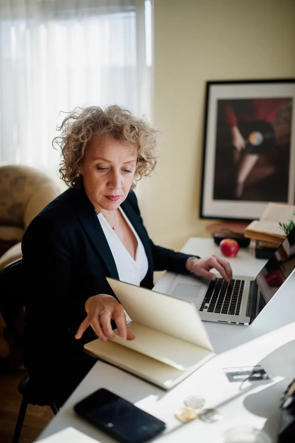 Assistant at a desk with a laptop and an open notebook